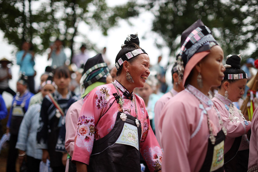8月5日，盛裝打扮的苗族村民在山頂上跳蘆笙舞。