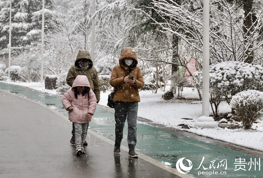 市民在觀山湖公園內(nèi)迎雪前行。人民網(wǎng) 顧蘭云攝