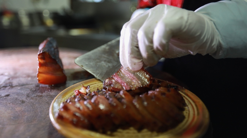 2023年1月2日，苗族群眾在切成品的臘肉。