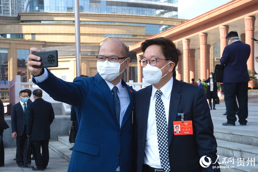政協(xié)委員站在會(huì)議中心門口合影留念。人民網(wǎng) 陽(yáng)茜攝