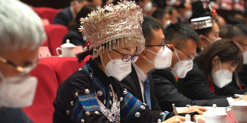 身著少數(shù)民族服飾的委員正在認(rèn)真記錄。人民網(wǎng) 陽茜攝