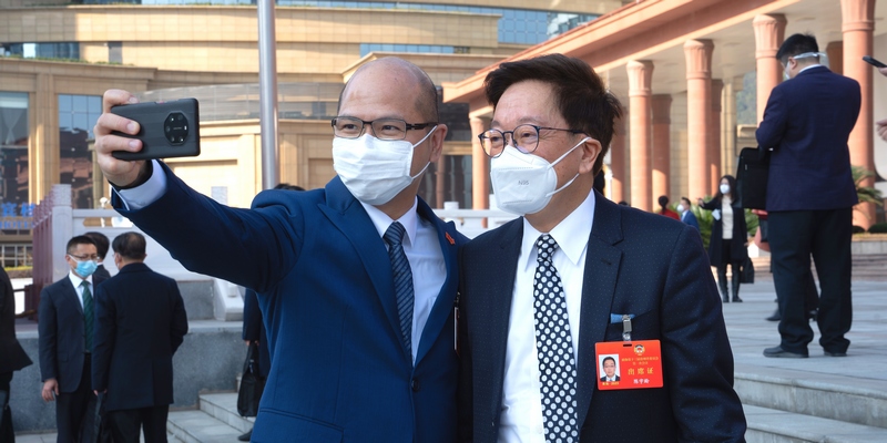 政協(xié)委員站在會(huì)議中心門口合影留念。人民網(wǎng) 陽茜攝