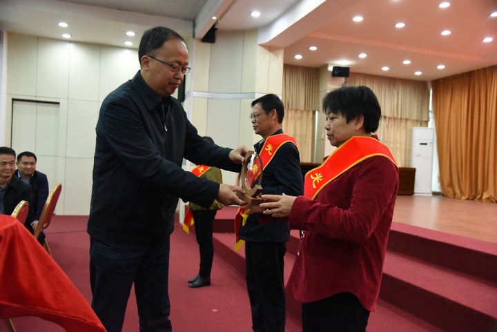 2 圖為冊亨縣委書記張茂同志為退休干部佩戴“光榮退休”綬帶并頒發(fā)紀(jì)念品。