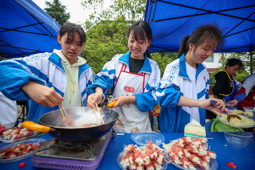 高三年級學(xué)生在“校園美食節(jié)”上烹飪美食。楊勝賢攝