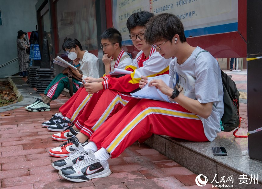 考生們?cè)谶M(jìn)考場(chǎng)前還在認(rèn)真復(fù)習(xí)。人民網(wǎng) 陽(yáng)茜攝