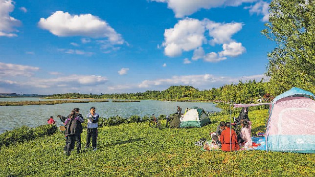 市民在貴安新區(qū)月亮湖公園草坪上休閑娛樂。 貴陽日?qǐng)?bào)融媒體記者 石照昌 攝