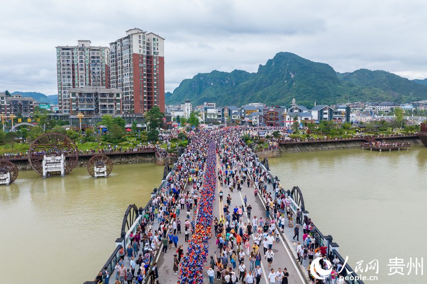 航拍身著民族盛裝巡游的少數(shù)民族同胞。人民網(wǎng)記者 涂敏攝