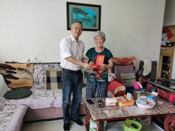 為金漫為張巧芝老黨員頒發(fā)“光榮在黨50年”紀(jì)念章。