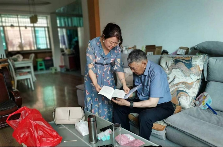 2 圖為為退休干部朱達(dá)昌送“學(xué)習(xí)包”并解讀政策、答疑解惑。
