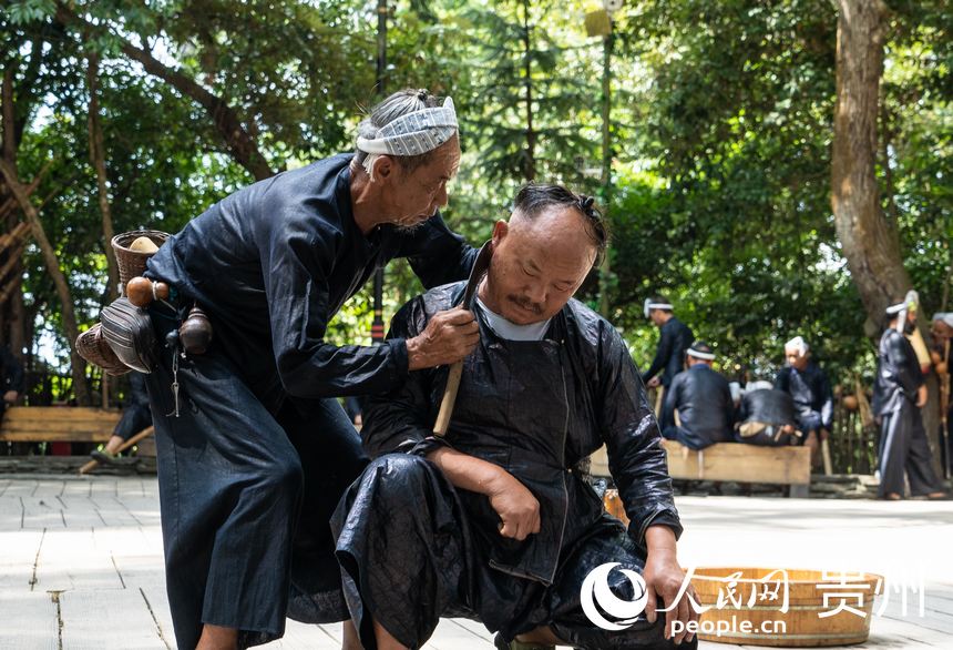 岜沙苗寨的鐮刀剃頭習(xí)俗。人民網(wǎng) 陽茜攝