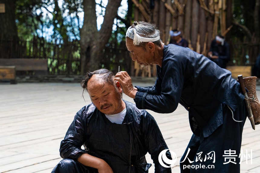 岜沙苗寨的鐮刀剃頭習(xí)俗。 人民網(wǎng) 陽茜攝