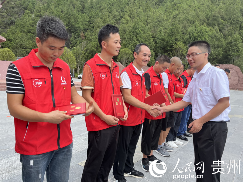 1.中共大烏江鎮(zhèn)委員會(huì)相關(guān)負(fù)責(zé)人為黨員貨車司機(jī)頒發(fā)聘書。人民網(wǎng) 李麗萍攝