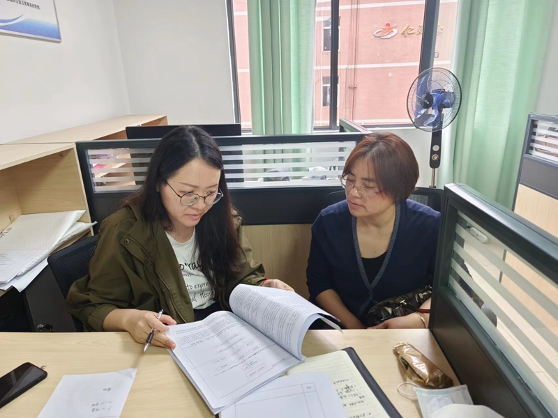 1.胡睿瑩（左）與其他老師進行教育教學業(yè)務探討。受訪者供圖