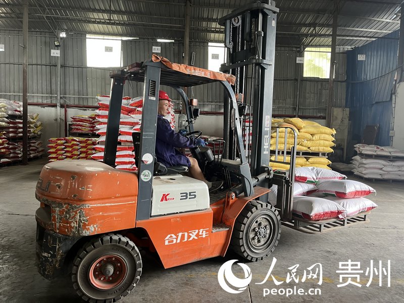 工人在貴州興邦農(nóng)業(yè)科技有限公司工廠里拖運飼料。人民網(wǎng) 李麗萍攝