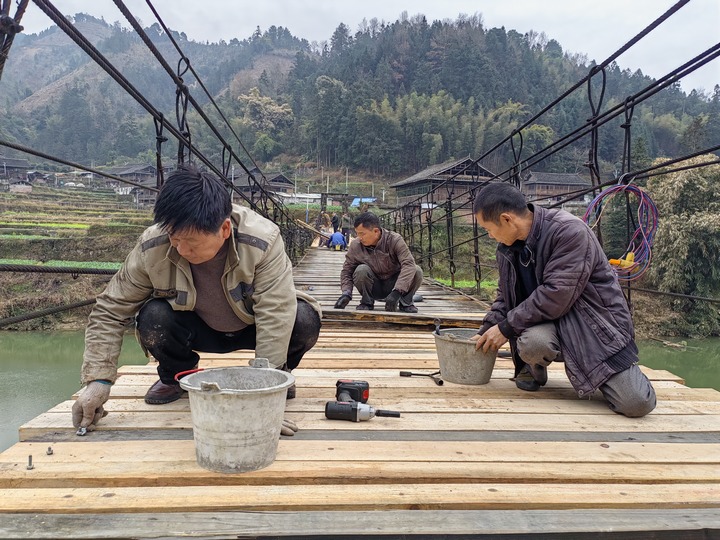 村民在修繕吊橋。董林丹攝