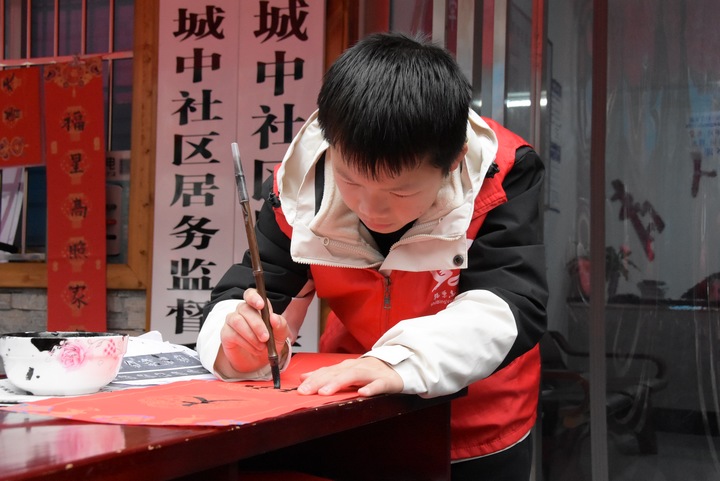 圖為參與活動的孩子書寫春聯(lián)。