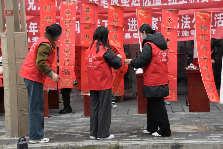 圖為志愿者對春聯(lián)進行整理供群眾挑選。