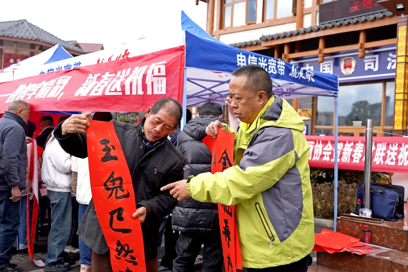 活動(dòng)現(xiàn)場(chǎng)，電信公司工作人員給市民讀春聯(lián)。楊英攝