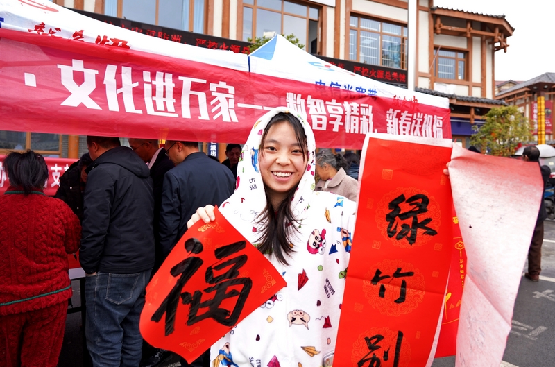 市民領(lǐng)取現(xiàn)場(chǎng)書寫的春聯(lián)。楊 英攝