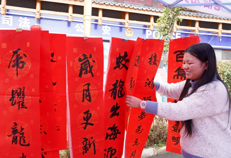 市民在挑選剛剛寫好的春聯(lián)。楊英攝