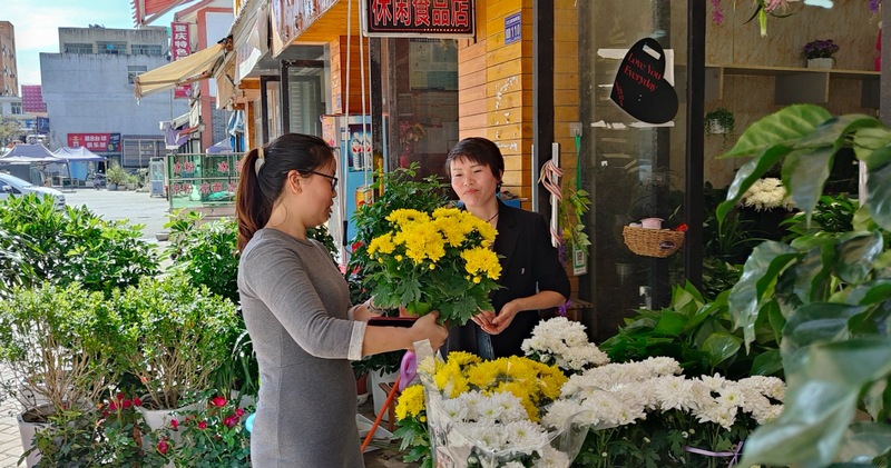 (1)王莊村村民冉毅云正在挑選鮮花祭品。.jpg