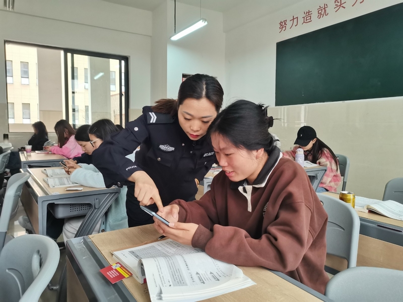 民警指導學生下載“國家反詐中心”APP。