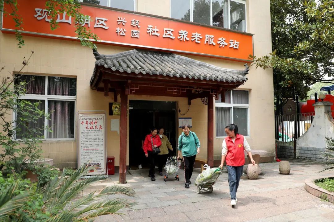 站點工作人員幫助老人送菜。