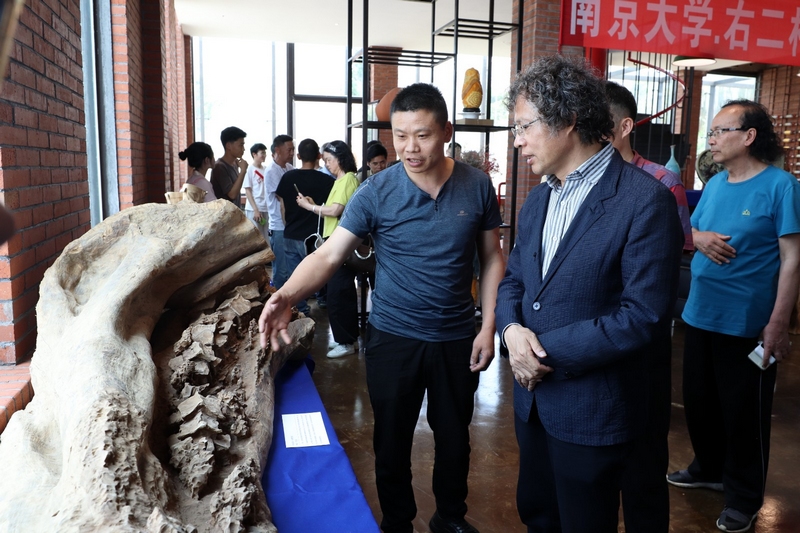 “兵工匠”劉吉武（左一）介紹其雕刻的工藝作品。