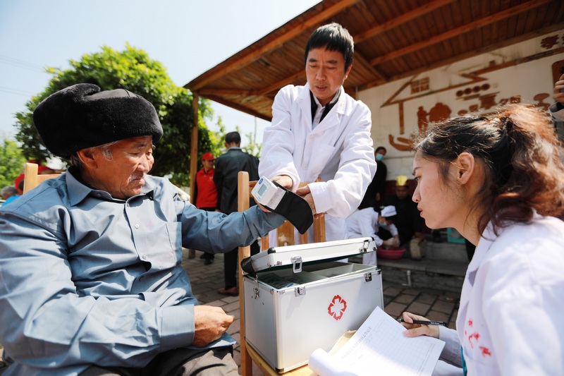 醫(yī)務(wù)人員和志愿者在貴州省黔西市林泉鎮(zhèn)敬老院為老人量血壓、測血糖。