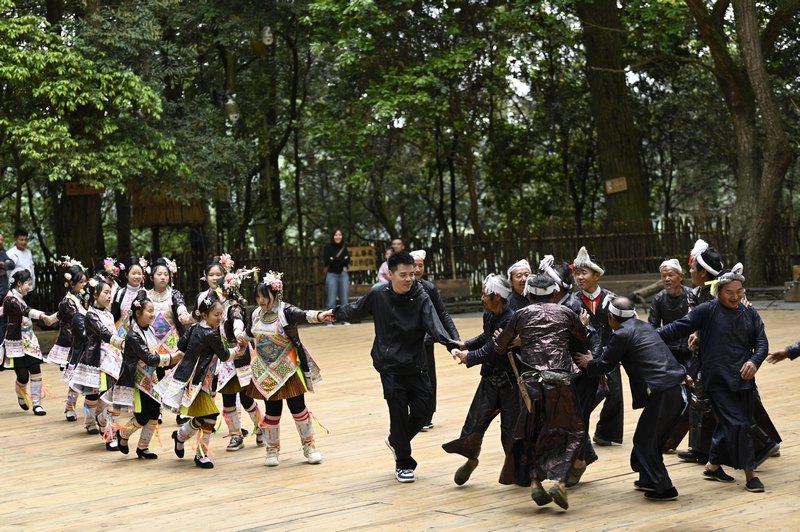 2024年5月1日，一名游客在貴州省從江縣丙妹鎮(zhèn)岜沙苗寨景區(qū)參與婚俗表演。