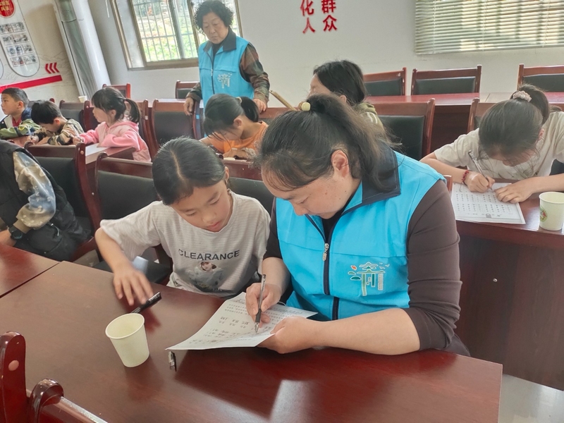 清鎮(zhèn)市大書(shū)法公益志愿服務(wù)隊(duì)在為農(nóng)村孩子輔導(dǎo)。（饒敏 攝）