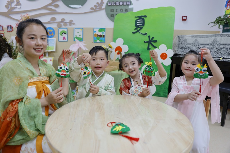 6月7日，在貴州省黔東南苗族侗族自治州施秉縣第四幼兒園，老師和小朋友展示剛做的香囊。磨桂賓攝