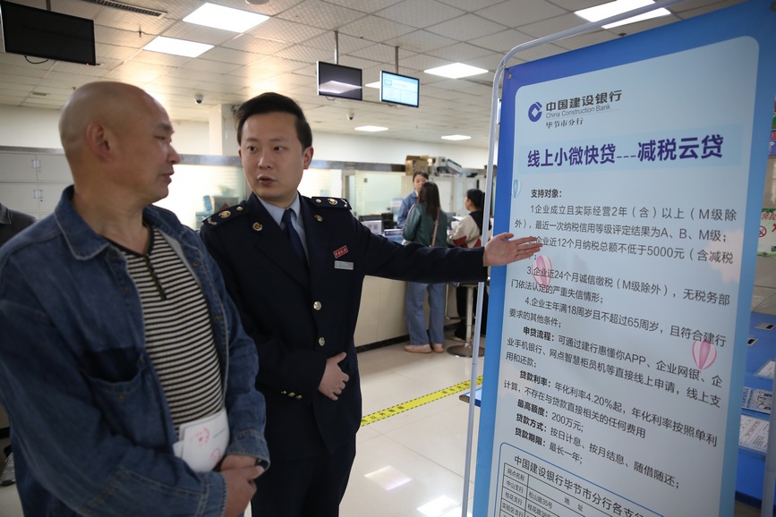 稅務(wù)人員向納稅人宣傳銀稅互動金融產(chǎn)品。