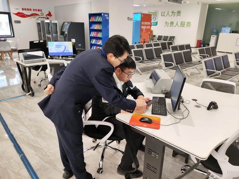 導(dǎo)稅人員輔導(dǎo)納稅人進(jìn)行手機操作