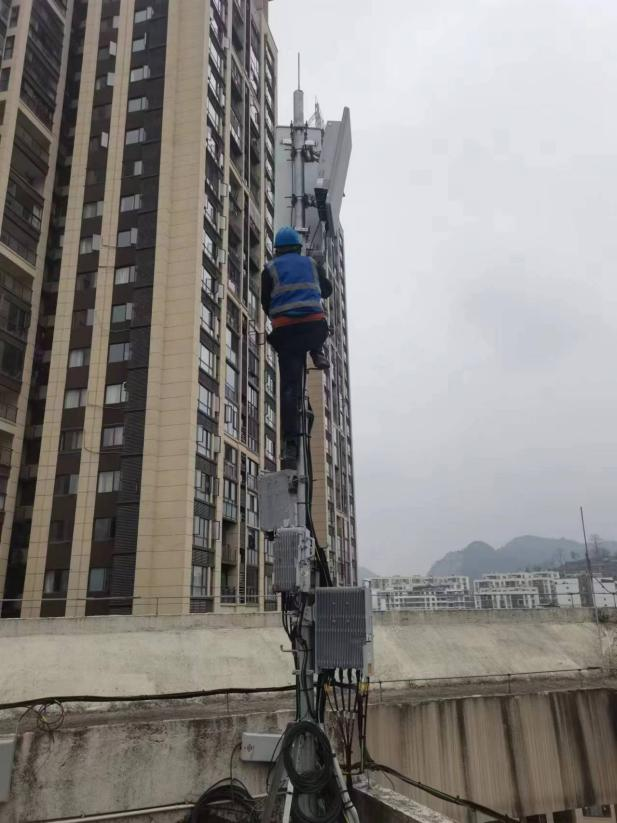 圖為移動(dòng)公司工作人員為小區(qū)住宅安裝移動(dòng)網(wǎng)絡(luò)設(shè)備。
