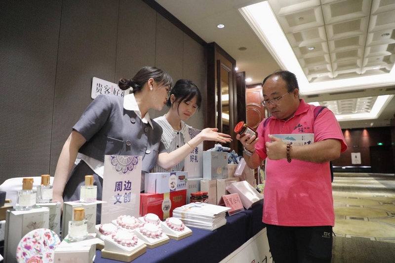 2、工作人員向參會(huì)嘉賓介紹貴州特產(chǎn)。