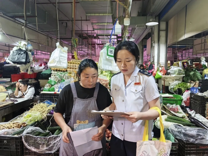 圖為稅務干部走進農貿市場輔導納稅人開具發(fā)票（沈金梅攝）