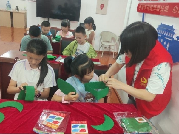 志愿者協(xié)助孩子們做手工。