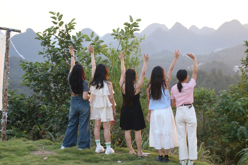 游客迎著夕陽拍照打卡。
