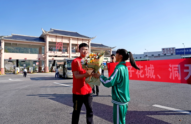 2024年9月20日上午，貴州省畢節(jié)市納雍高速收費站，學(xué)生代表向回家的奧運冠軍謝瑜獻花。 楊英 攝