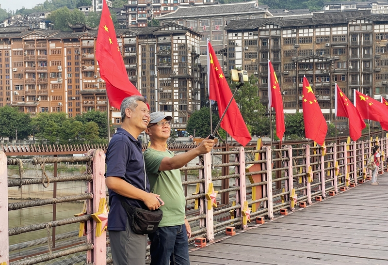 4、臺(tái)灣游客曾正義在橋上與友人合照。