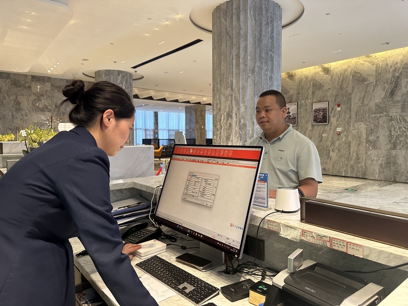 酒店工作人員為游客郭治武辦理入住