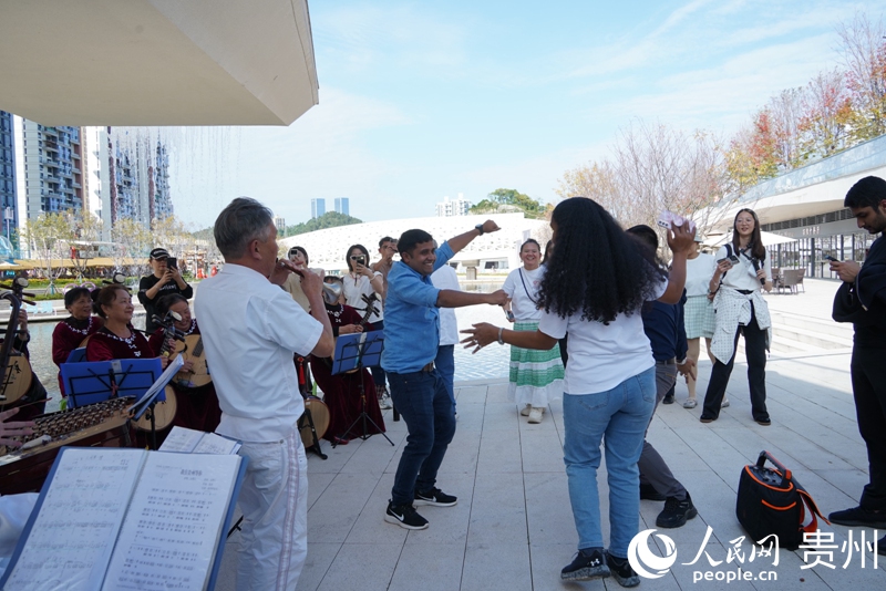 外媒記者主動(dòng)加入到當(dāng)?shù)乩夏陿逢?duì)的表演中。人民網(wǎng) 陽茜攝