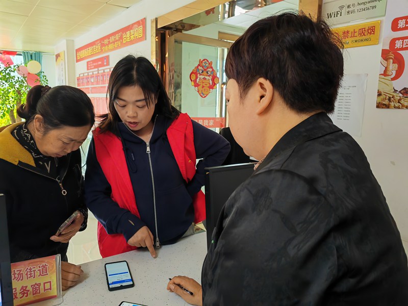 社區(qū)工作人員耐心地為居民解答有關(guān)醫(yī)保政策的疑問(wèn)  黃源匯 攝 (2)