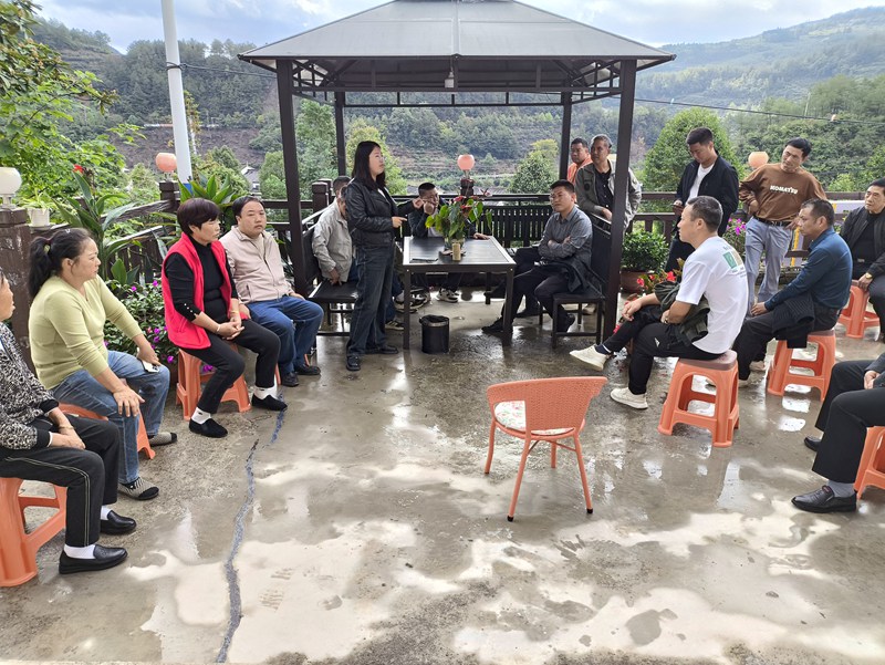 圖為：龍廣村副支書陳朝義同志向村民悶介紹民宿的運(yùn)行模式