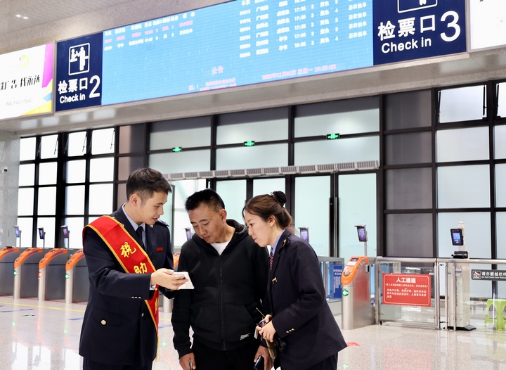 聯(lián)合服務(wù)團隊向旅客宣傳“電子客票”并輔導(dǎo)開具。何博攝