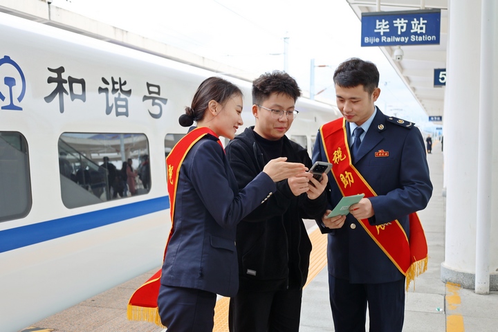 在高鐵站，鐵路+稅務(wù)聯(lián)合服務(wù)團隊向旅客宣傳“電子客票”并輔導(dǎo)開具。楊蝶攝