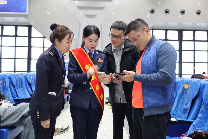 在高鐵站候車大廳，鐵路+稅務(wù)聯(lián)合服務(wù)團隊向旅客宣傳“電子客票”并輔導(dǎo)開具。何博攝