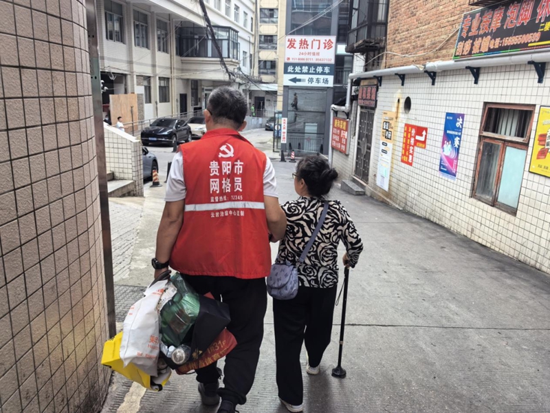 社區(qū)幫助獨居老人李阿姨就醫(yī)。