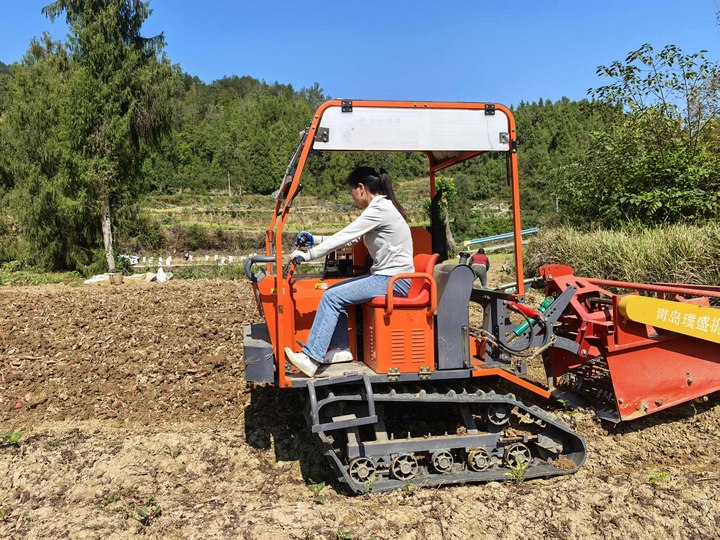 村民駕駛農(nóng)機(jī)在田間作業(yè)。